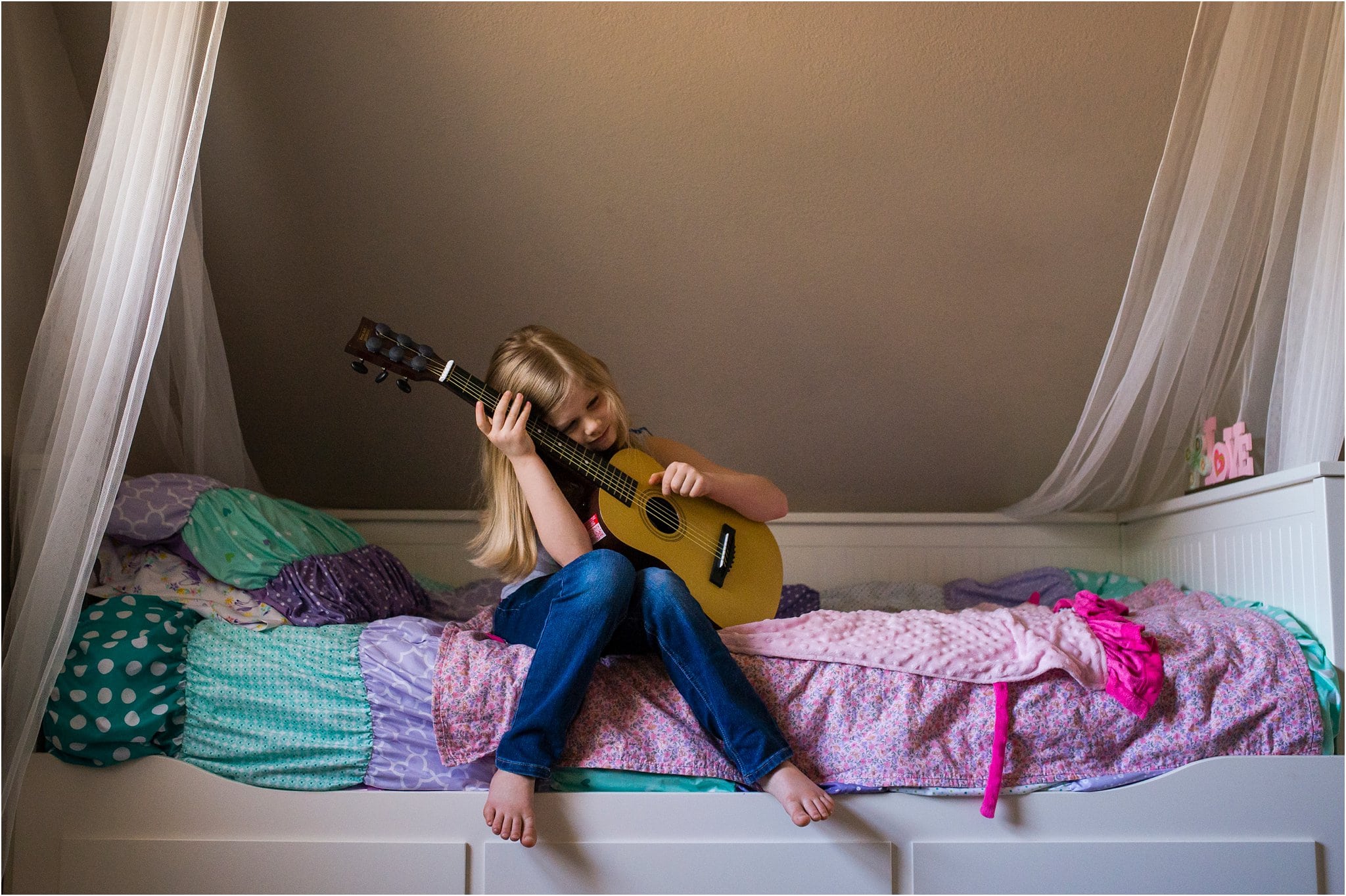 girl on bed playing guitar 