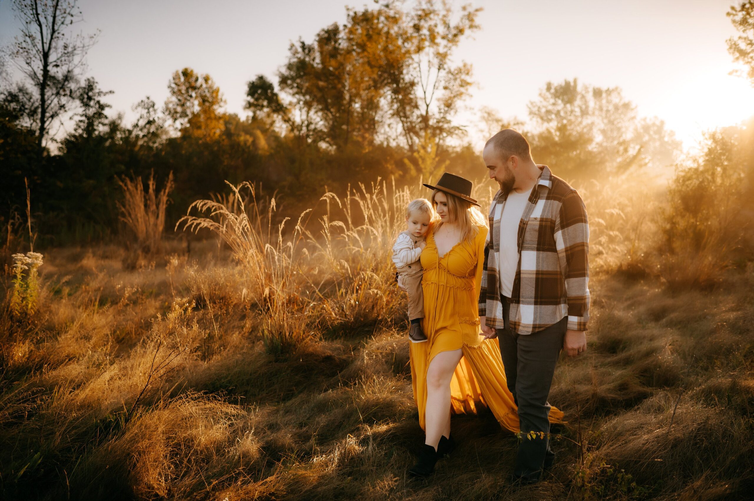 Findlay Ohio Photographer family of 3 walking in grass at sunrise photo by cynthia dawson photography