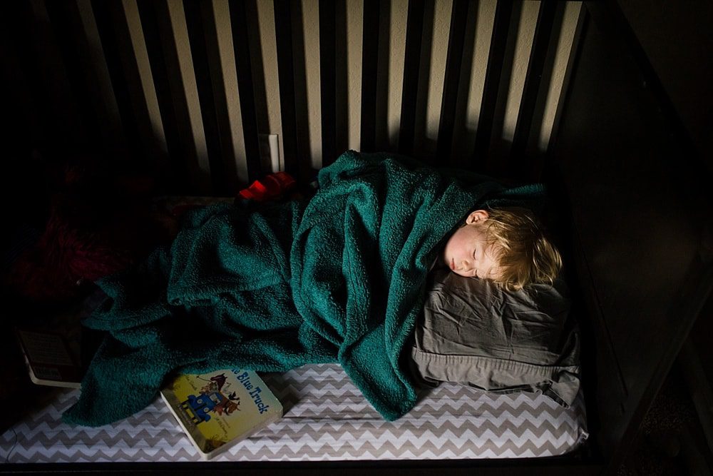 Perrysburg Storytelling Photographer over head view of toddler sleeping in crib photo by cynthia dawson photography