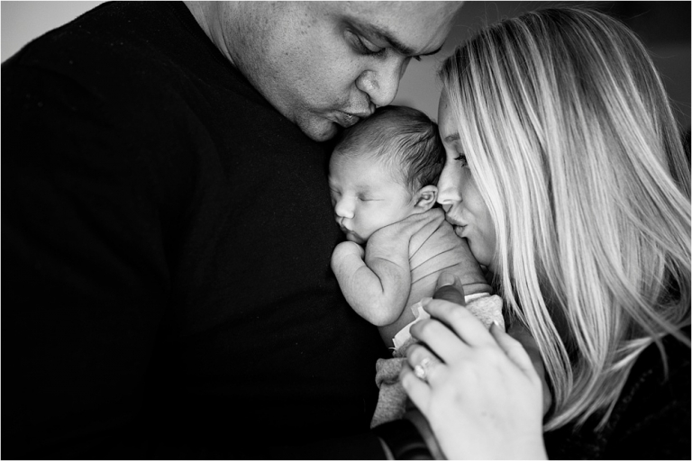 Toledo OH Newborn Photographer parents kissing newborn daughter photo by Cynthia Dawson Photography