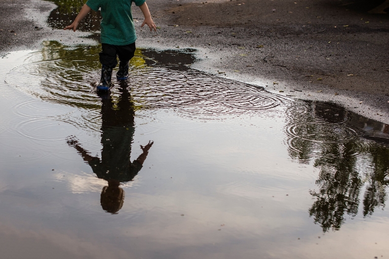 Lifestyle Photography Northwest Ohio boy standing in puddle photo by Cynthia Dawson Photography