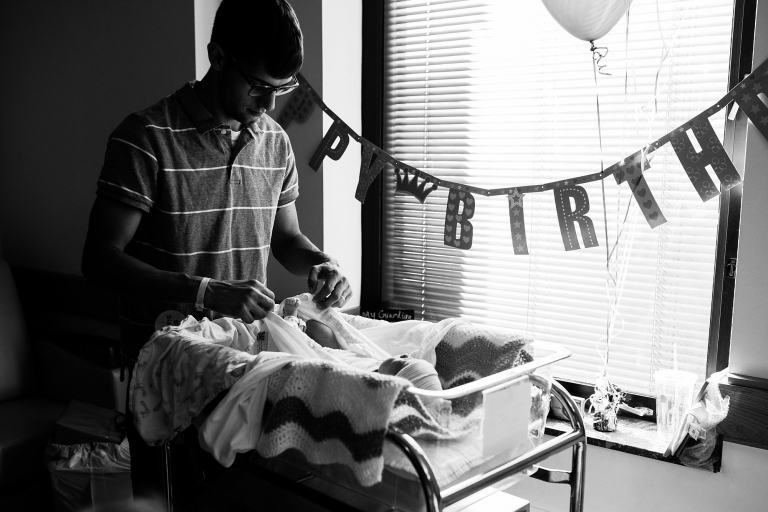 Toledo Newborn Photographers dad changing newborn photo by Cynthia Dawson Photography