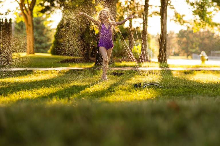 Toledo Ohio Lifestyle Photographer girl in sprinkler photo by Cynthia Dawson Photography