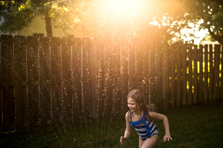 Toledo Ohio Summer Photo Session girl running through sprinkler photo by Cynthia Dawson Photography