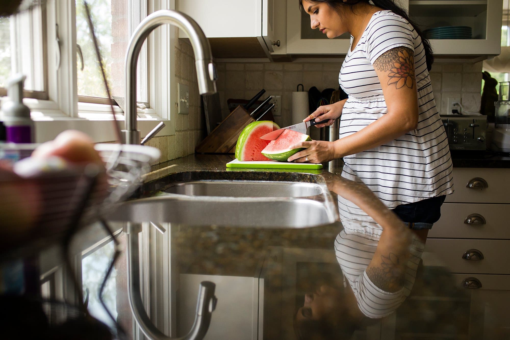 Toledo Lifestyle Maternity Photographer pregnant woman cutting watermelon photo by Cynthia Dawson Photography