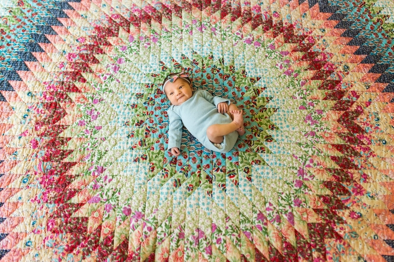 Toledo Ohio Newborn Lifestyle Photography newborn girl on colorful blanket photo by Cynthia Dawson Photography