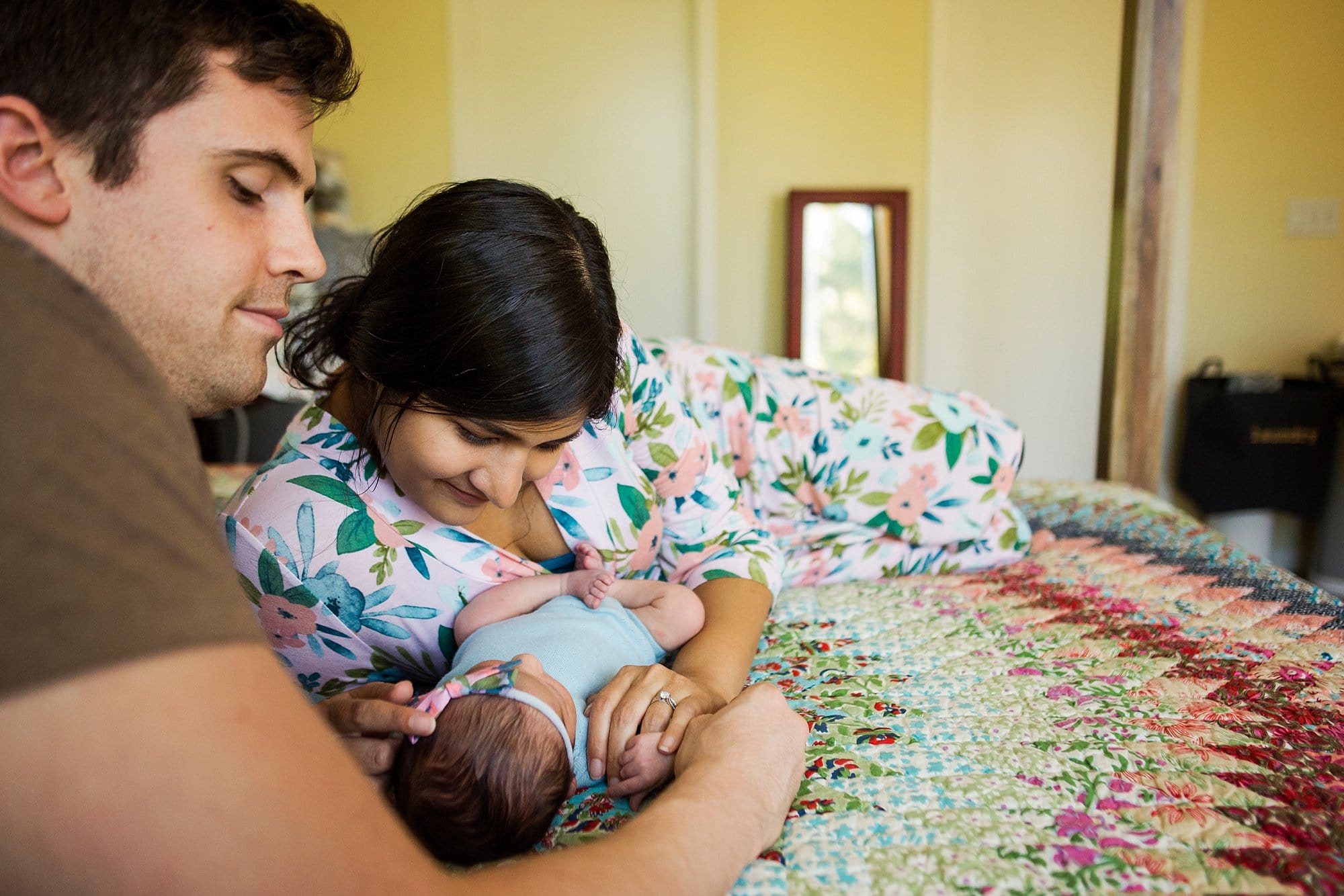 Toledo Ohio Newborn Lifestyle Photography parents looking at newborn photo by Cynthia Dawson Photography