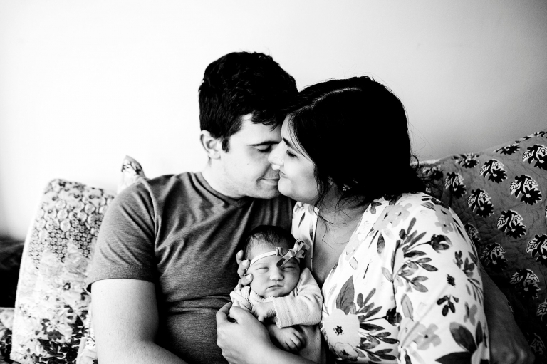 Toledo Ohio Newborn Lifestyle Photography parents kissing with newborn photo by Cynthia Dawson Photography