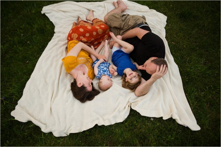 Northwest Ohio Family Lifestyle Photographer family laying on grass together photo by Cynthia Dawson Photography