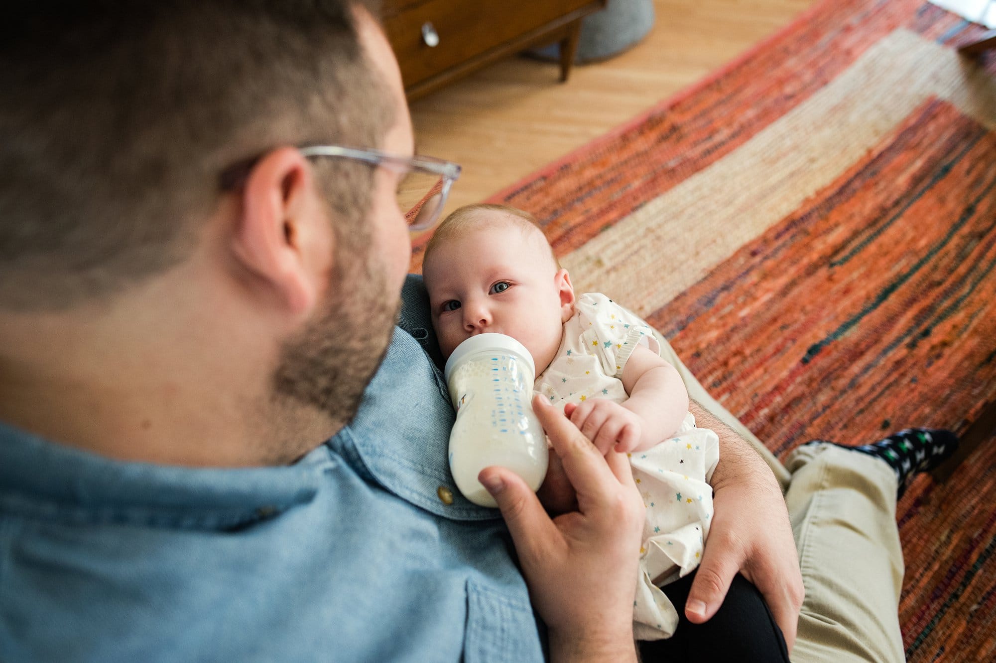 Lifestyle Photographer in Perrysburg Ohio dad feeding baby photo by Cynthia Dawson Photography 