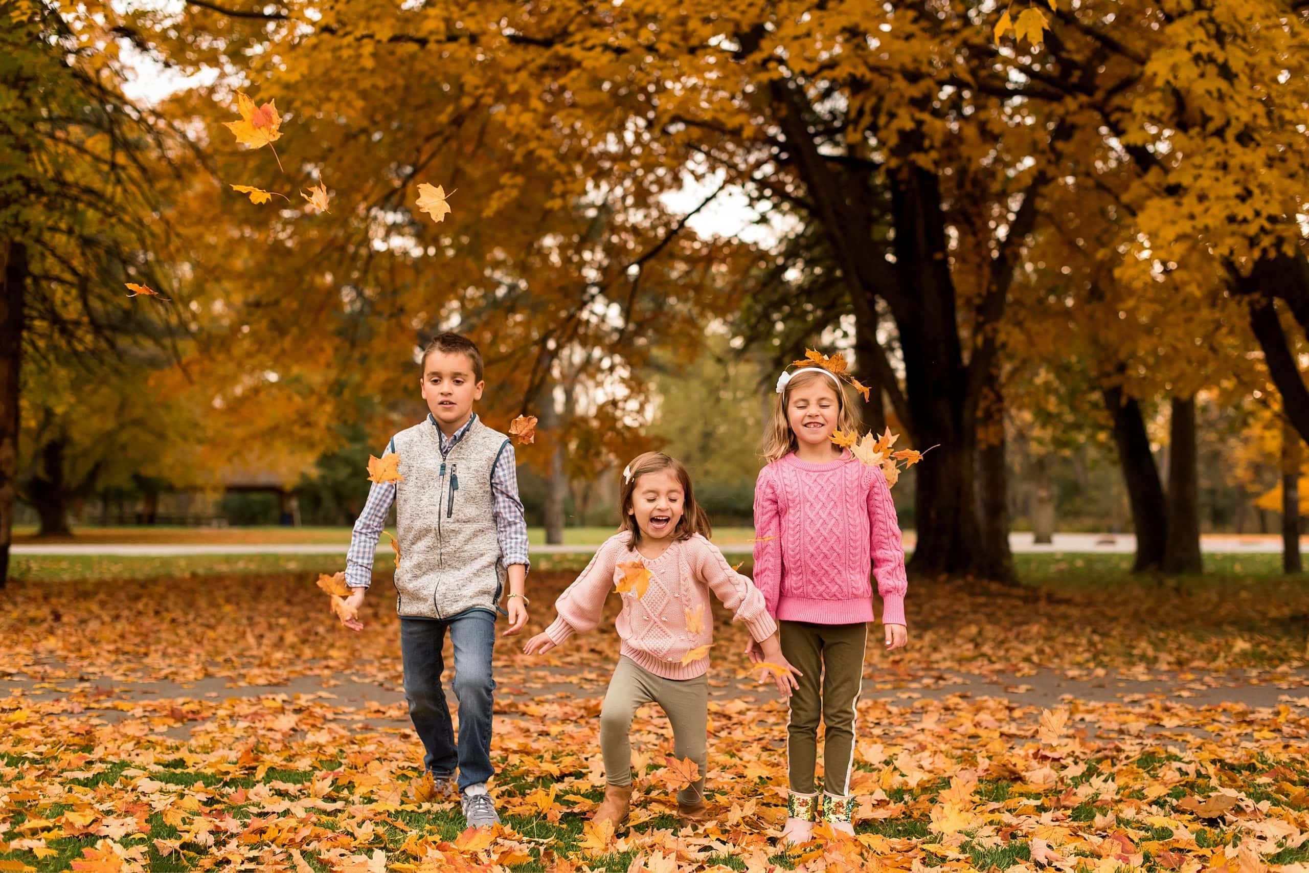 children throwing leaves at side cut park in maumee ohio photo by cynthia dawson photography 