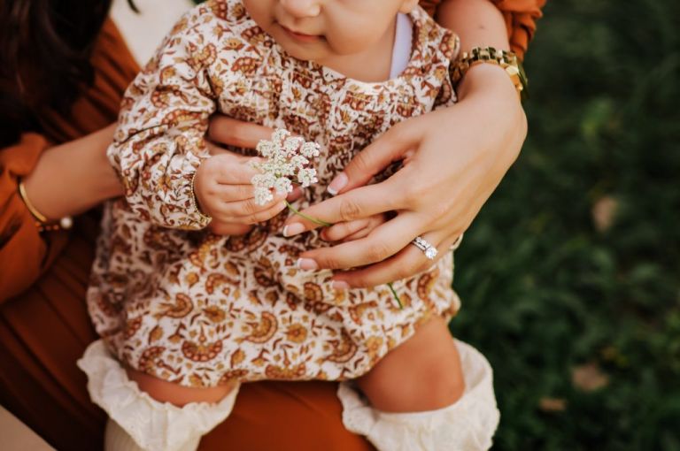 mother holding baby girl with flower photo by cynthia dawson photography