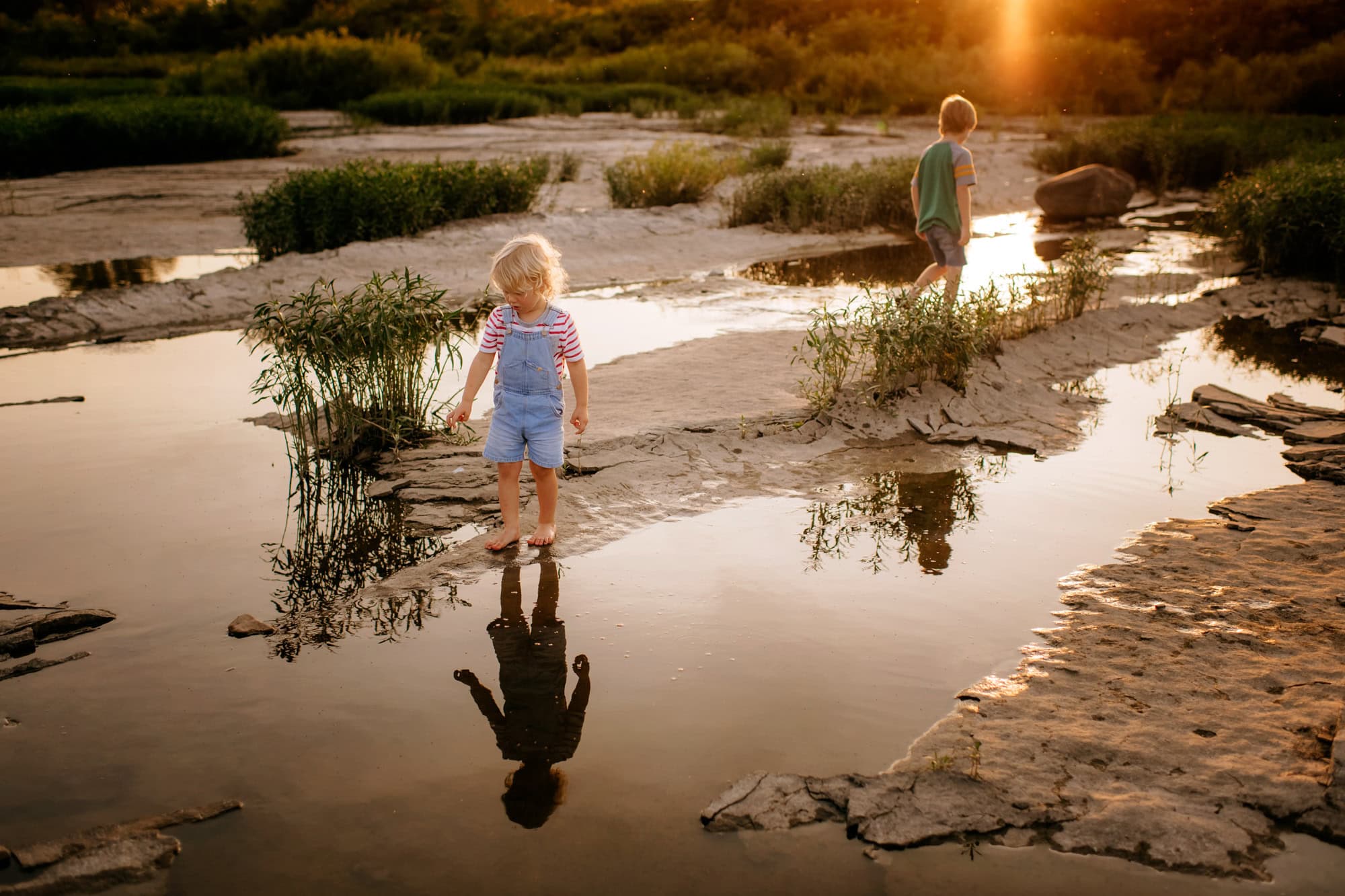 two kids exploring river at maumee river in maumee, ohio